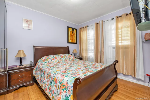 a bedroom with a bed and wooden floor