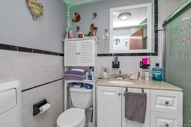 a bathroom with a sink vanity mirror and toilet