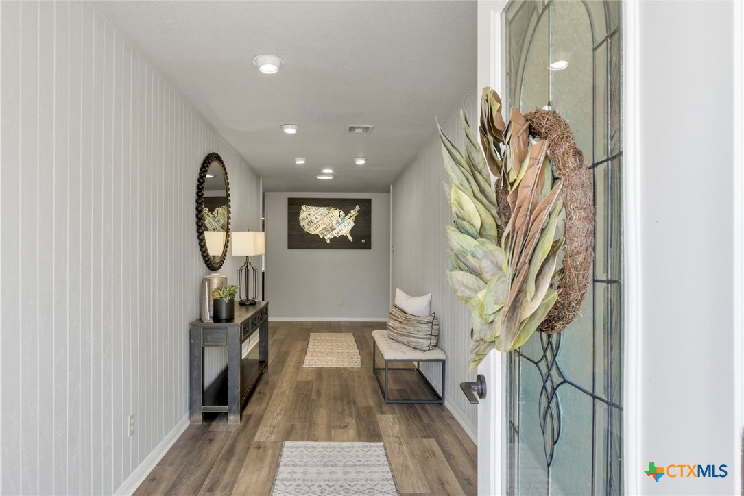 1710 Old Mill Road, Unit 12 Salado, TX 76571 - Photo 12 of 42 a view of a hallway with wooden floor and a potted plant