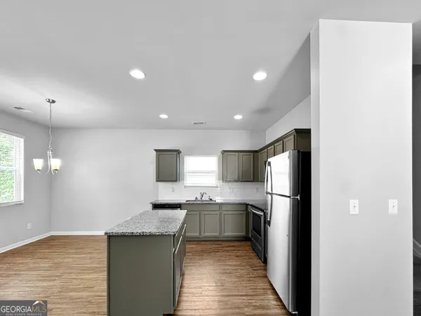 a kitchen with stainless steel appliances granite countertop a refrigerator a sink a stove and oven
