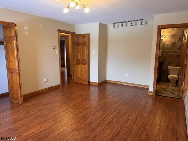 a view of a hallway with wooden floor and closet