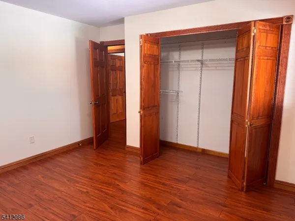 an empty room with wooden floor and a window