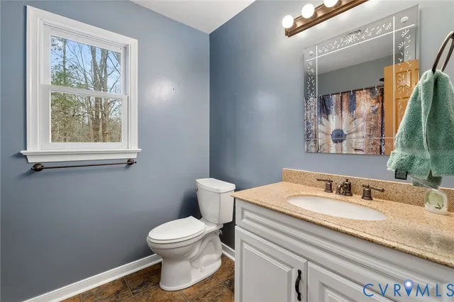 a bathroom with a granite countertop bathtub sink vanity mirror and toilet
