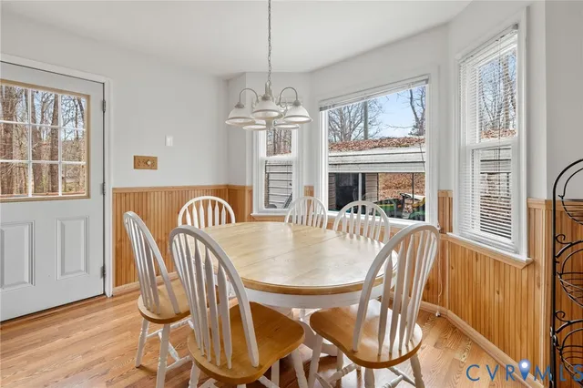 a dining room with furniture a chandelier and wooden floor