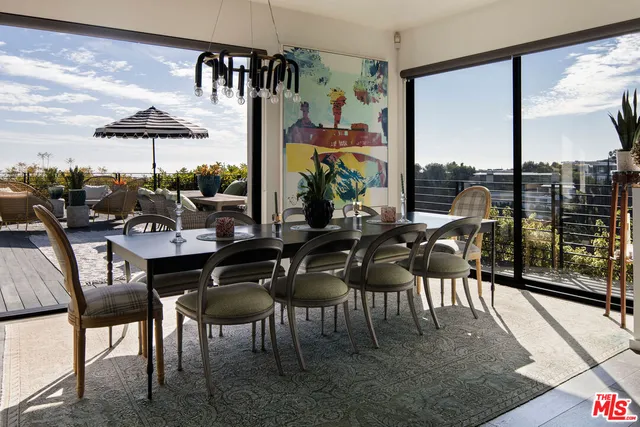 a dinning table and chairs in front of a glass door