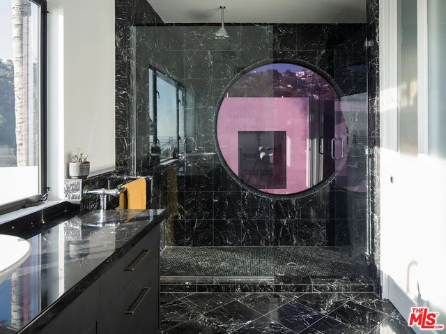 a kitchen with sink and large window wooden cabinets