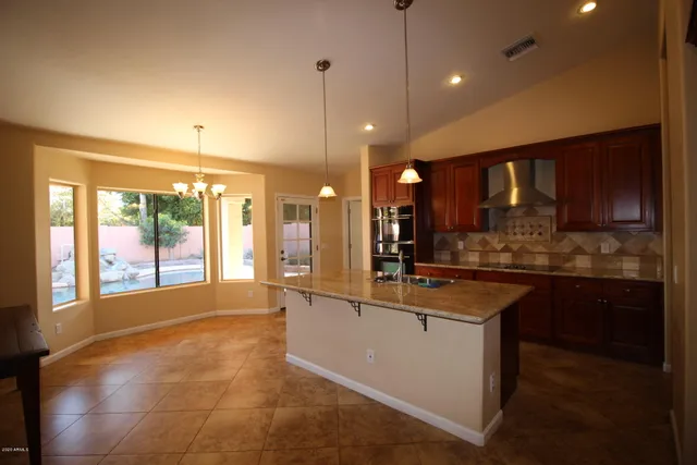 a view of kitchen with granite countertop white cabinets and black appliances