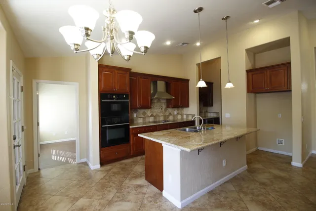 a kitchen with granite countertop a sink stainless steel appliances and cabinets