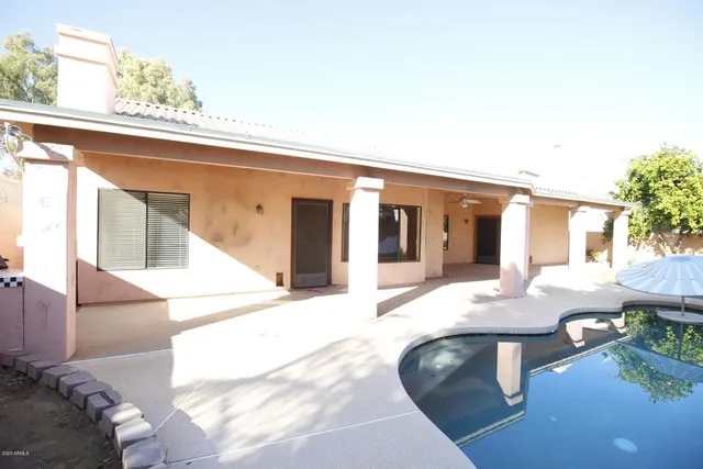 a view of a house with backyard and sitting area