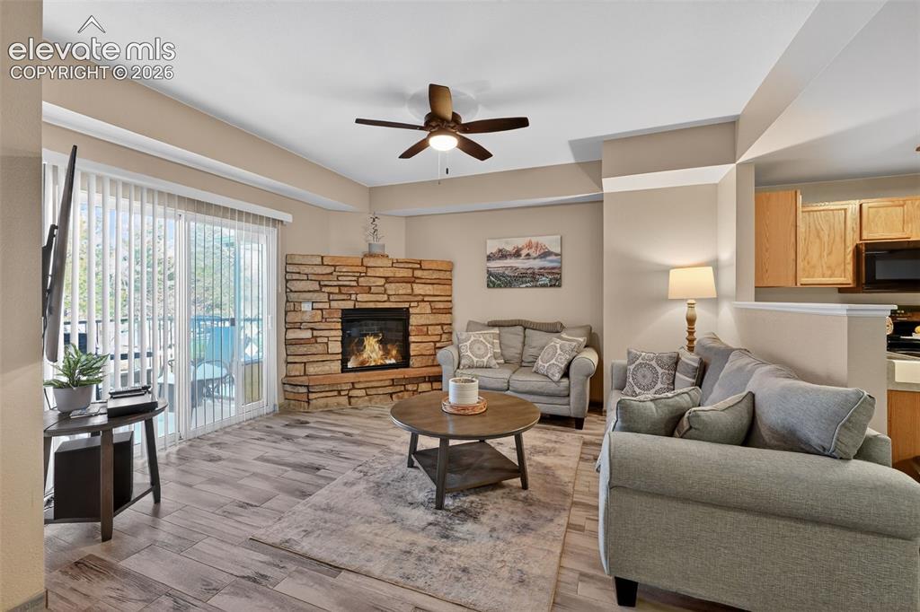 2141 Legacy Ridge View, Unit 109 Colorado Springs, CO 80910 - Photo 3 of 23 a living room with furniture a fireplace and a large window