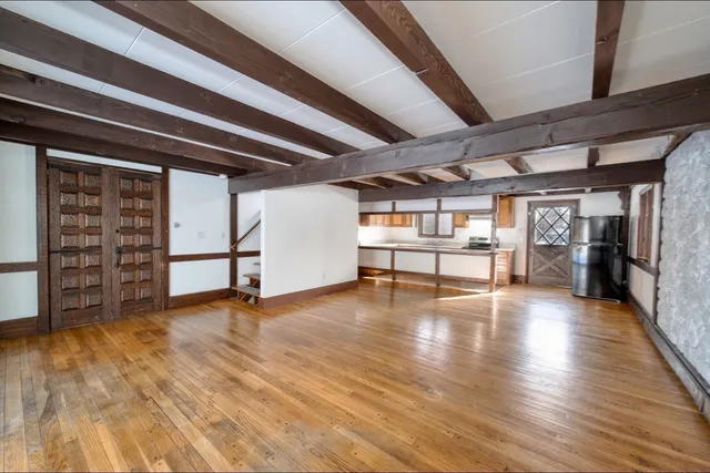 a view of a livingroom with wooden floor and a ceiling fan
