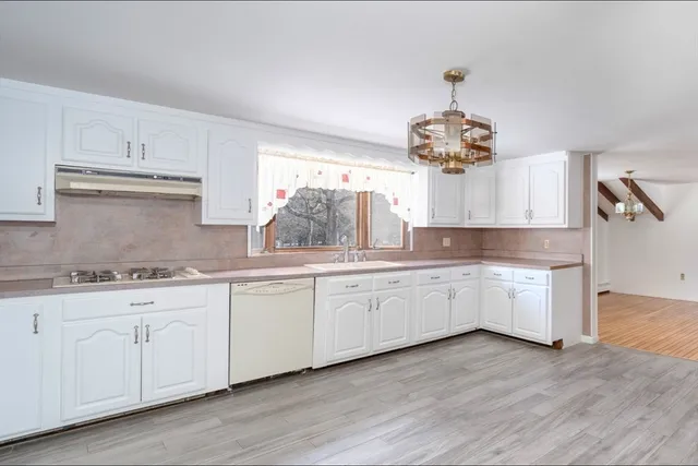 a kitchen with granite countertop white cabinets and white appliances