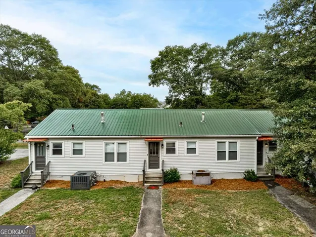 a front view of a house with a yard and trees