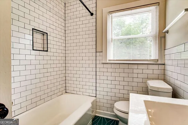 a bathroom with a toilet a sink and bathtub