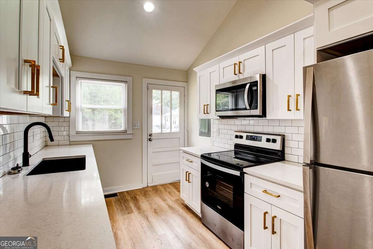 210 Bryan Street McDonough, GA 30253 - Photo 2 of 24 a kitchen with granite countertop a refrigerator stove and sink