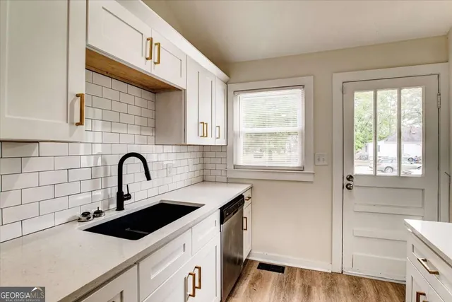 a view of a kitchen with a sink and wooden floor