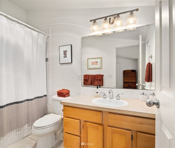 a bathroom with a granite countertop sink mirror vanity and toilet