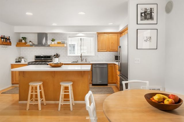 a kitchen with a table chairs sink and cabinets