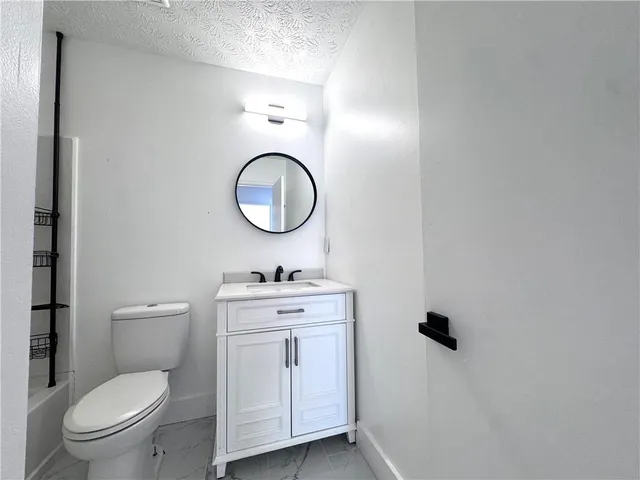 a bathroom with a toilet a sink and mirror
