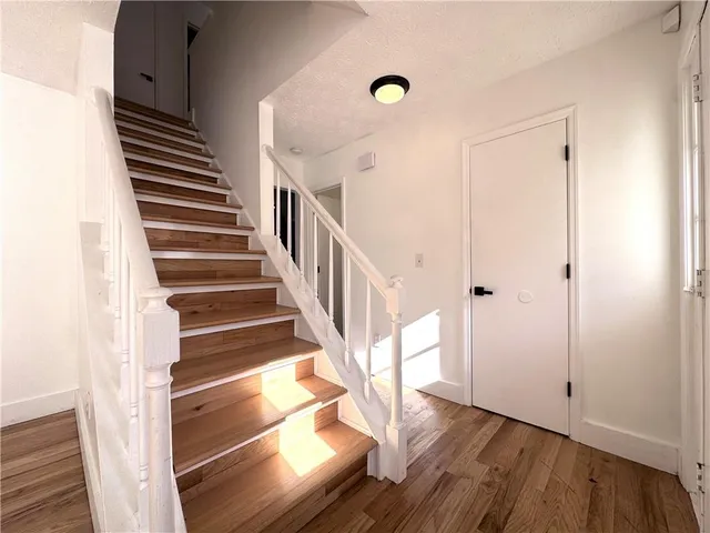 a view of entryway and hall with wooden floor