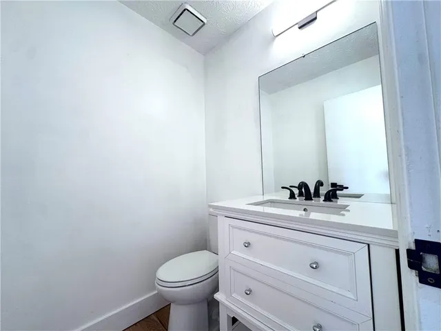a bathroom with a sink a toilet and mirror