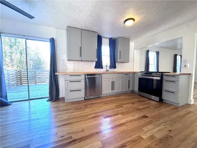 a view of kitchen with granite countertop a stove and a wooden floors