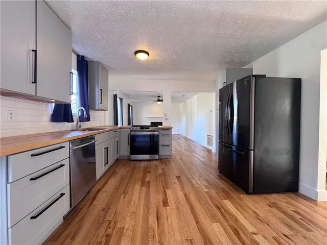 a kitchen with wooden floors appliances and cabinets