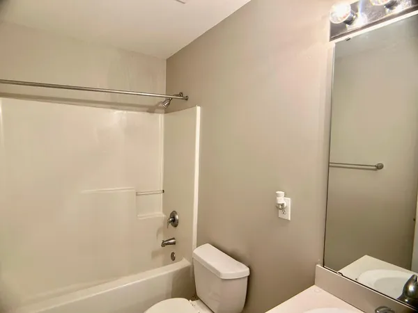 a bathroom with a shower a toilet and a sink
