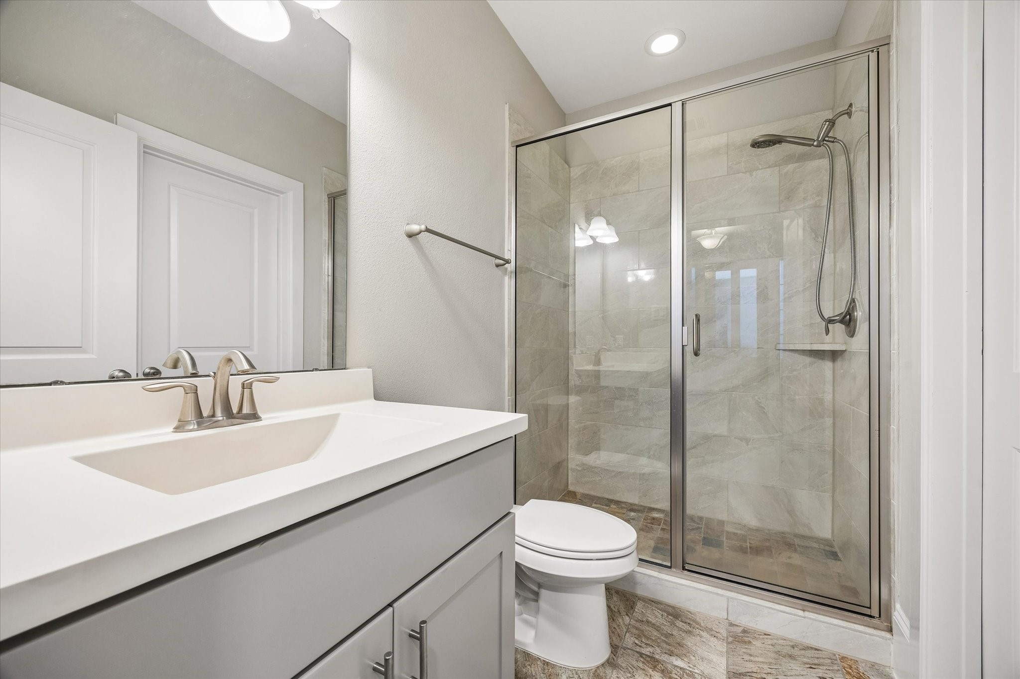 8318 Ginger Oak Street Houston, TX 77055 - Photo 13 of 20 a bathroom with a sink mirror a toilet and shower