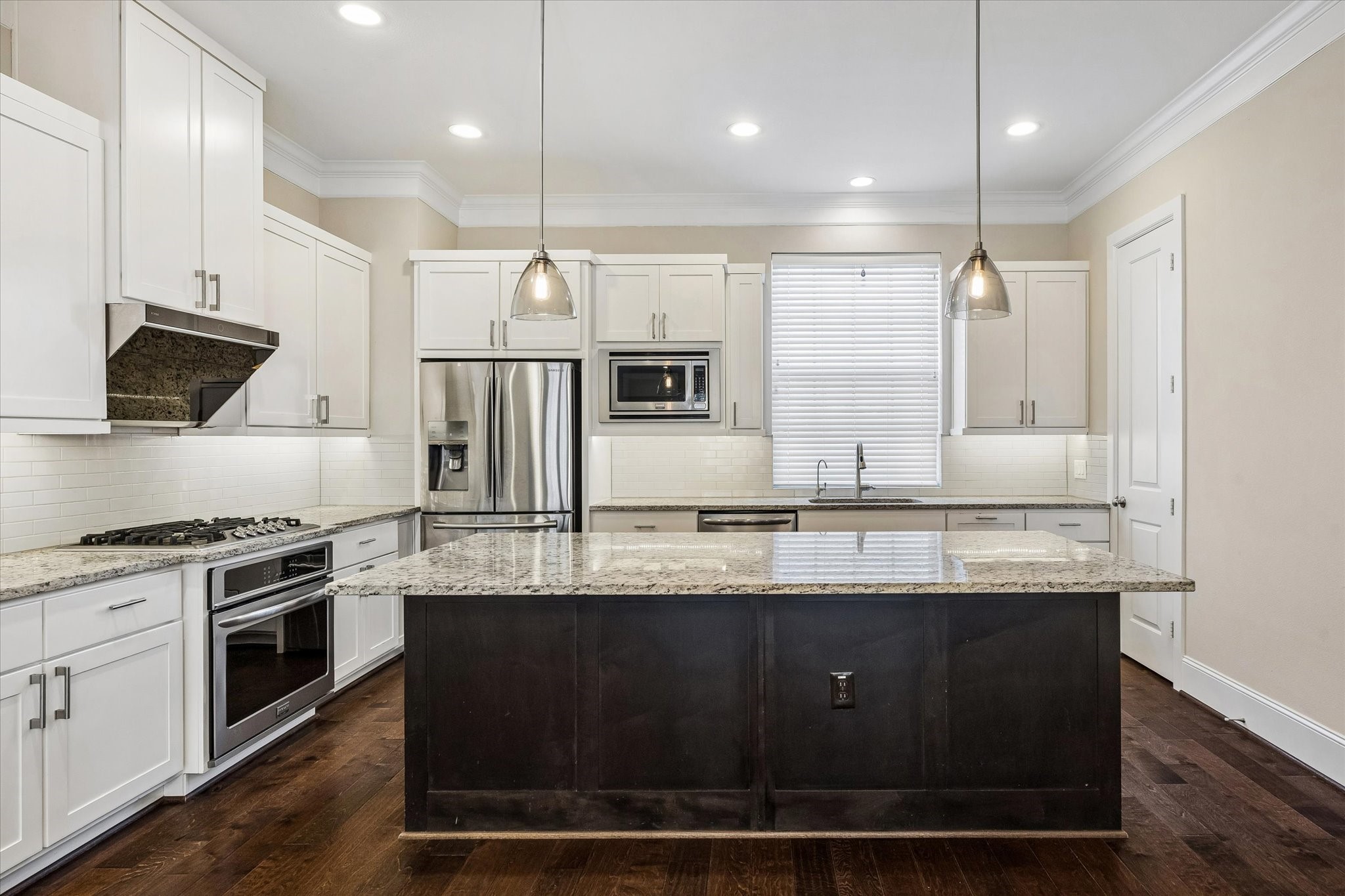 8318 Ginger Oak Street Houston, TX 77055 - Photo 3 of 20 a large kitchen with granite countertop a stove a sink a refrigerator and a microwave