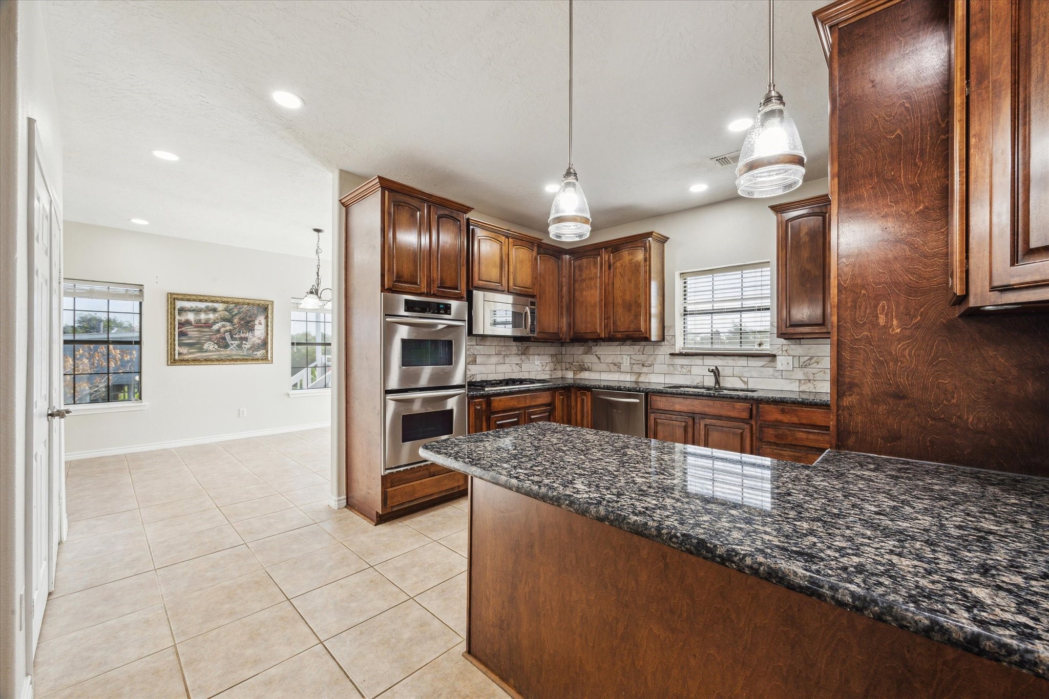 216 Rue Orleans Street Baytown, TX 77520 - Photo 11 of 43 a kitchen with stainless steel appliances granite countertop a sink refrigerator and cabinets