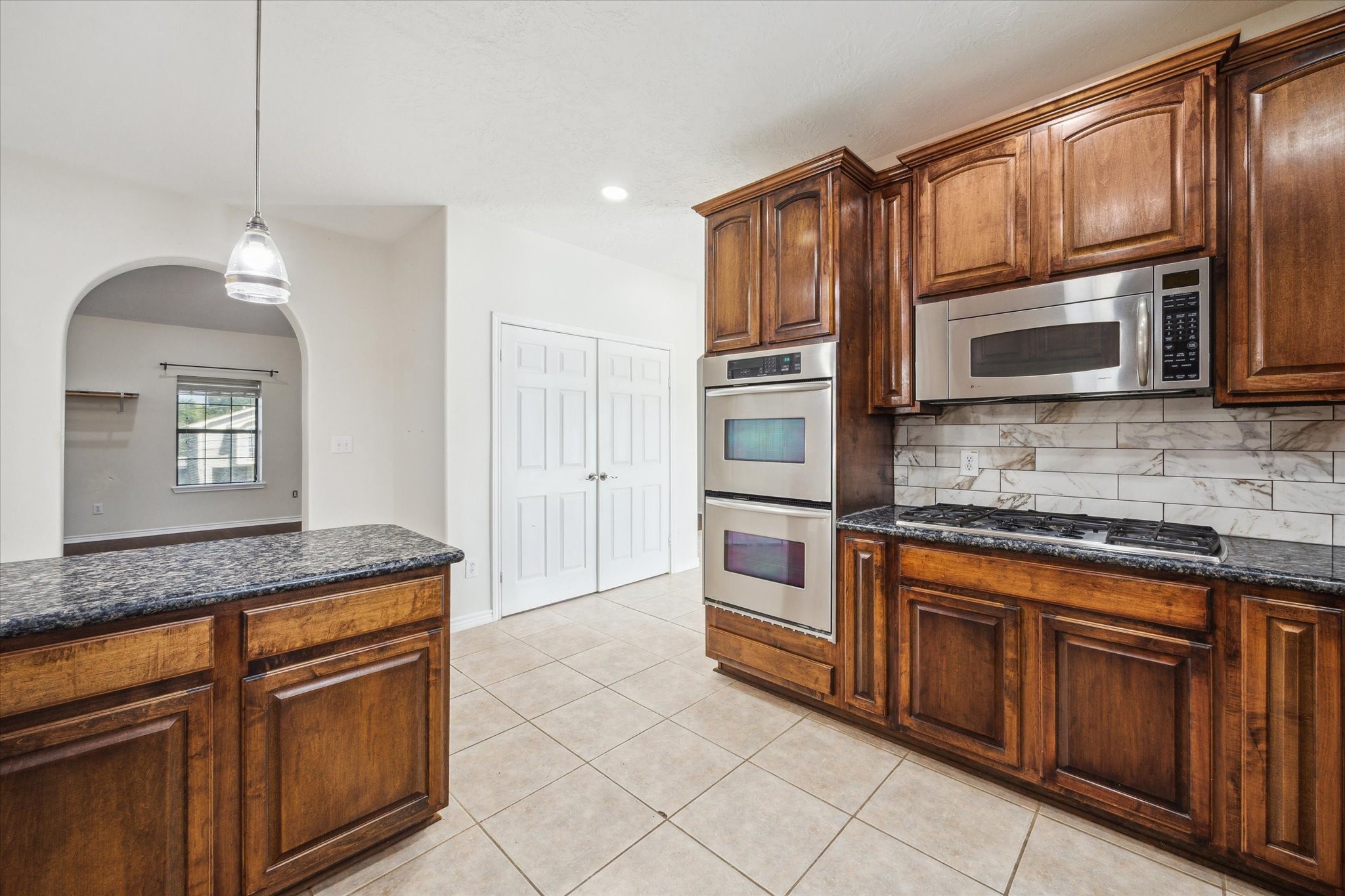 216 Rue Orleans Street Baytown, TX 77520 - Photo 13 of 43 a kitchen with stainless steel appliances granite countertop a stove microwave and refrigerator