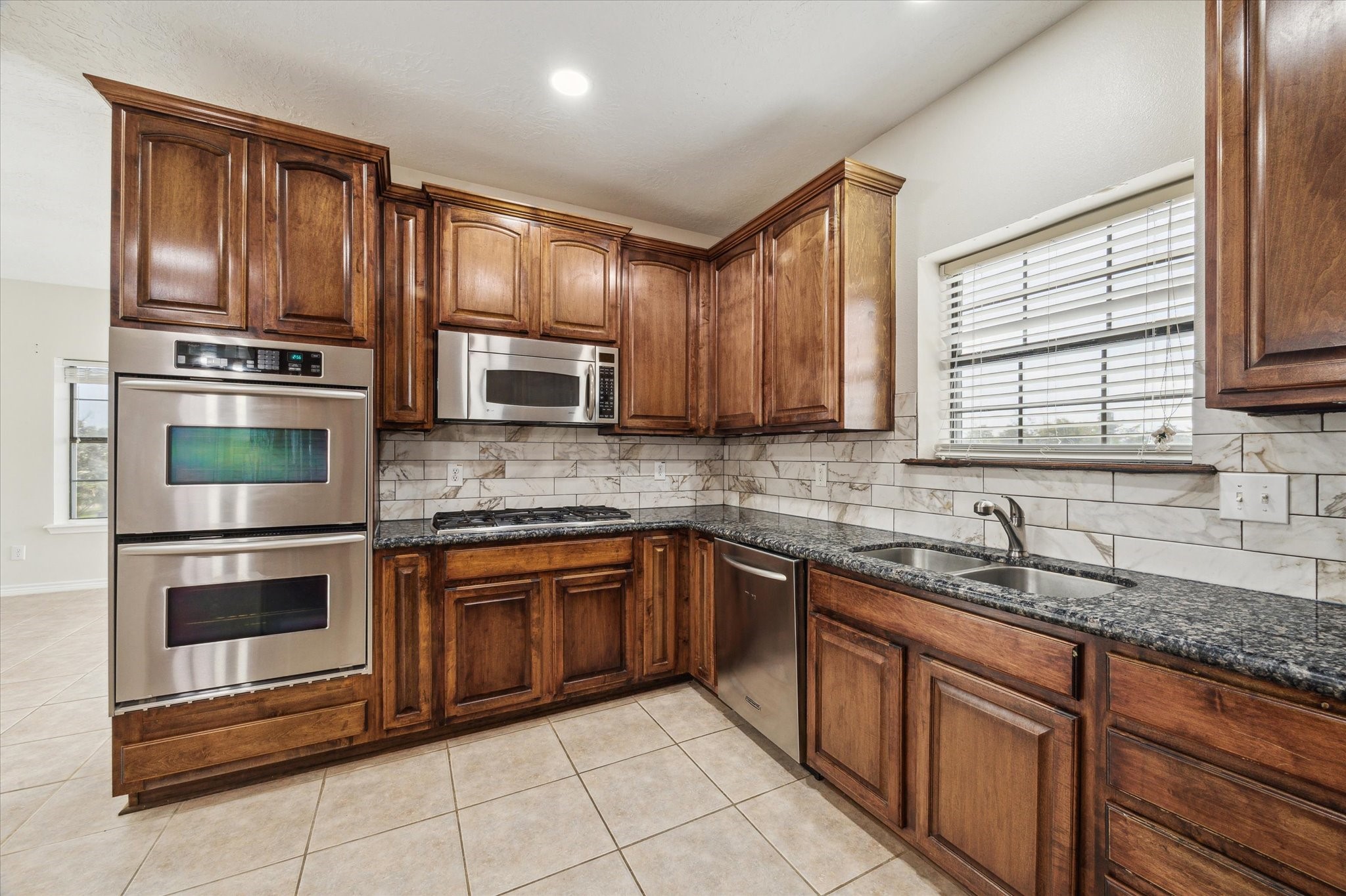 216 Rue Orleans Street Baytown, TX 77520 - Photo 14 of 43 a kitchen with stainless steel appliances granite countertop a sink stove and microwave