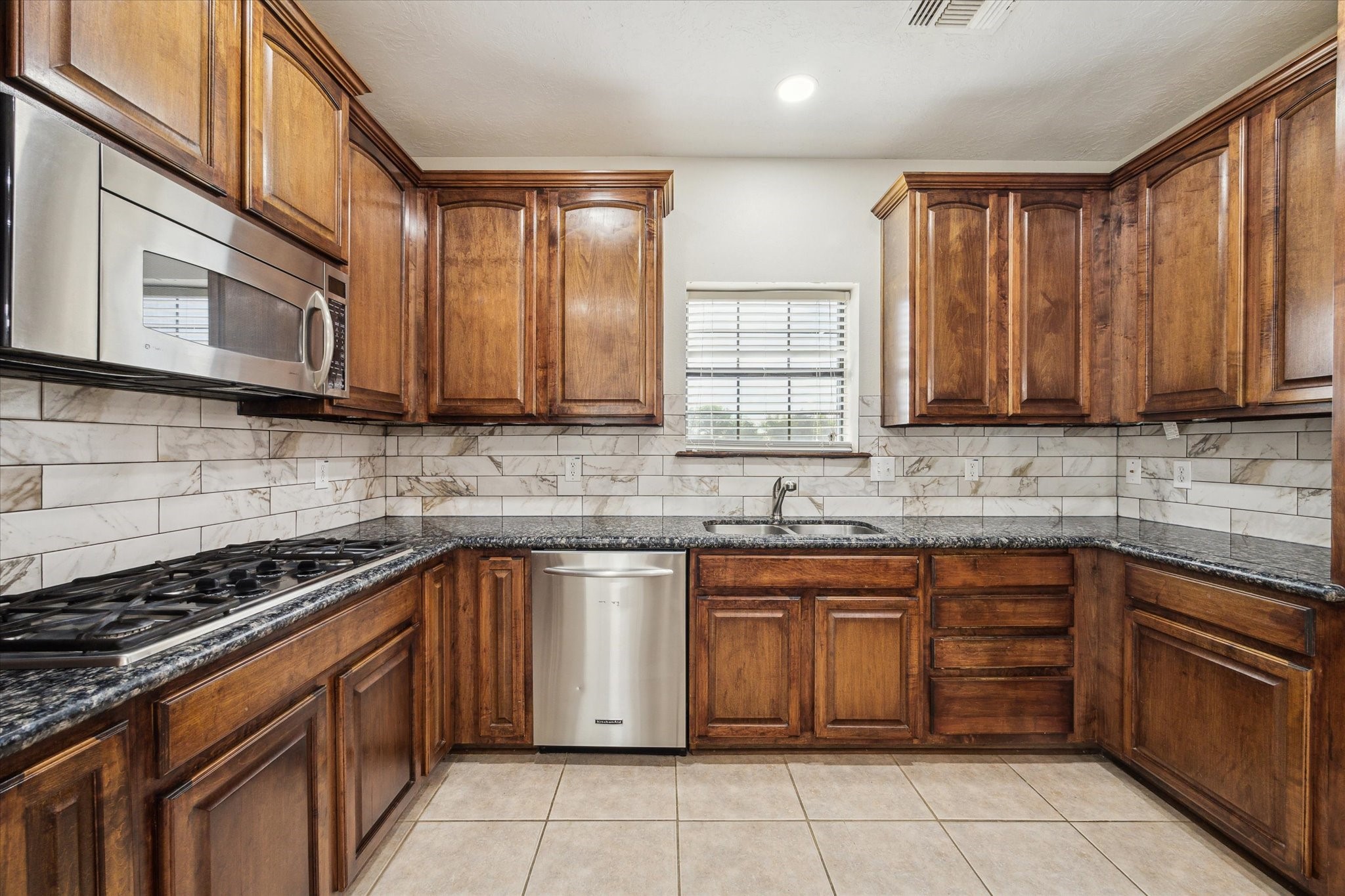 216 Rue Orleans Street Baytown, TX 77520 - Photo 15 of 43 a kitchen with stainless steel appliances granite countertop a stove sink microwave and cabinets