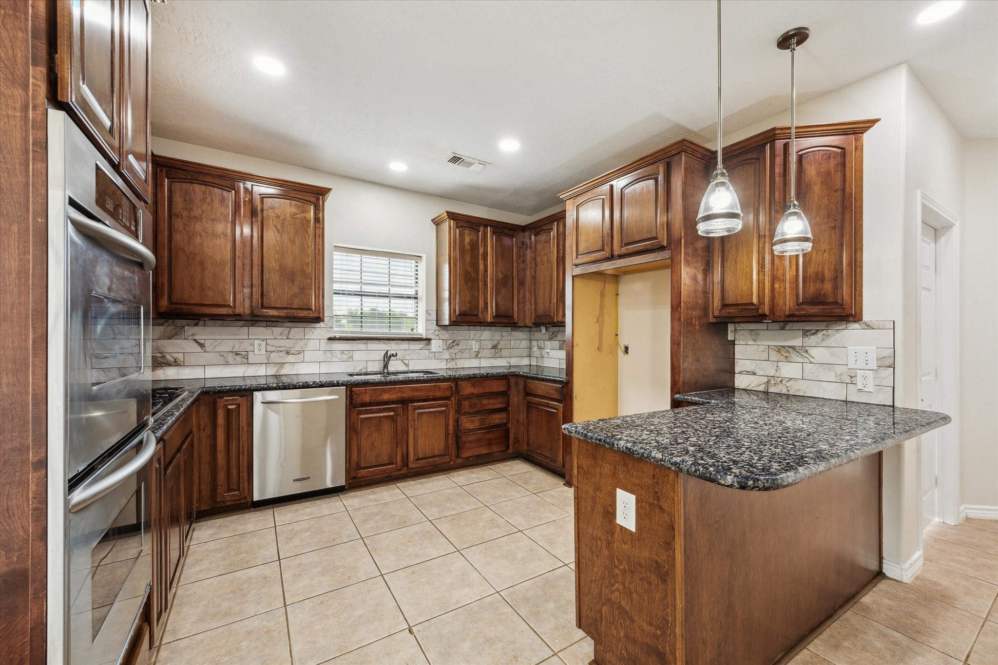 216 Rue Orleans Street Baytown, TX 77520 - Photo 3 of 43 a kitchen with stainless steel appliances granite countertop wooden cabinets a sink dishwasher a stove and a refrigerator
