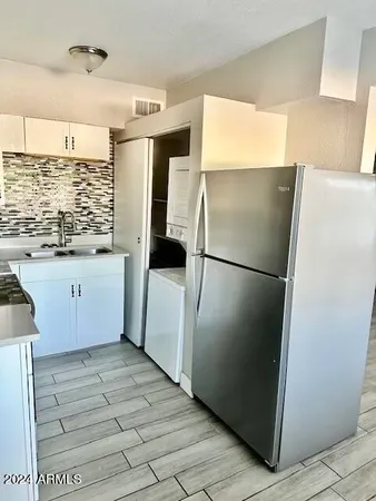 a kitchen with granite countertop a refrigerator and a sink