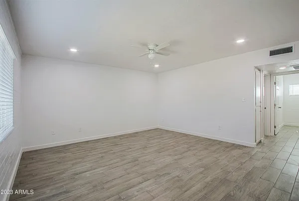 an empty room with a window and a ceiling fan