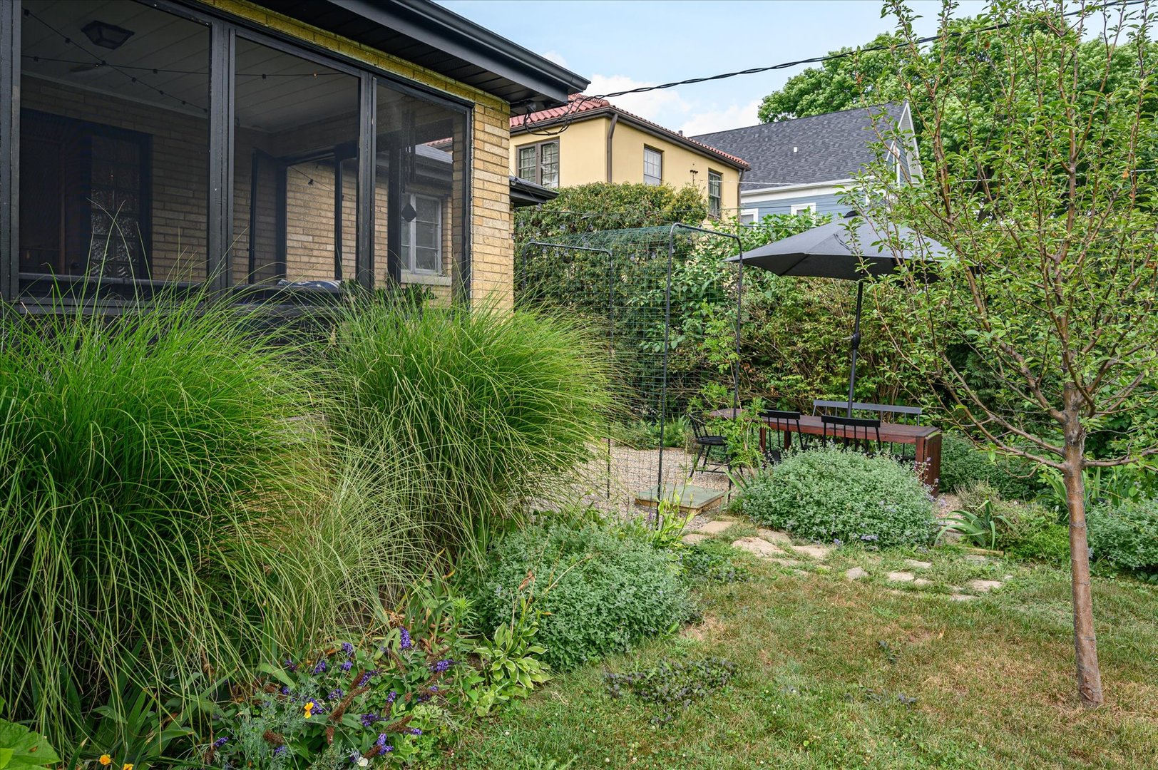 277 Olmsted Road Riverside, IL 60546 - Photo 32 of 34 a backyard of a house with table and chairs under an umbrella