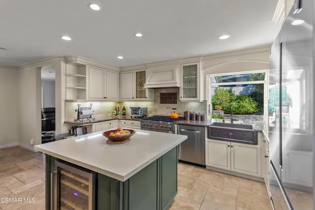 a kitchen with a refrigerator a stove top oven a sink dishwasher and white cabinets with wooden floor