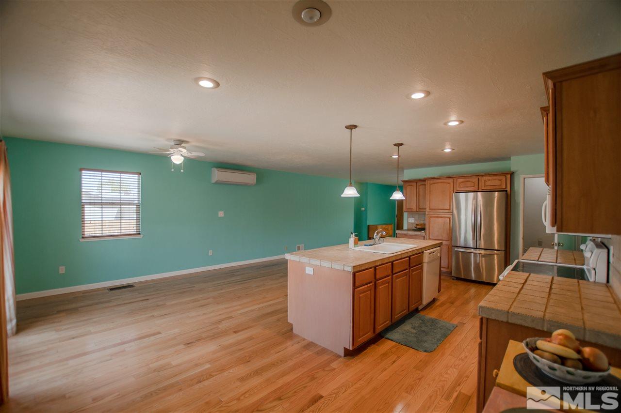 255 West Plumb Lane, Unit NV Reno, NV 89509 - Photo 8 of 25 a kitchen with kitchen island a sink stove and wooden floor