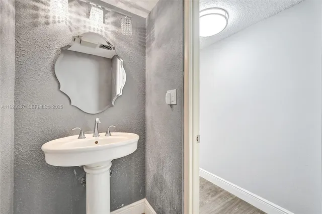 a bathroom with a granite countertop toilet a sink and a large mirror