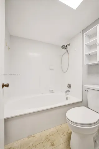 a view of a big room with wooden floor and windows