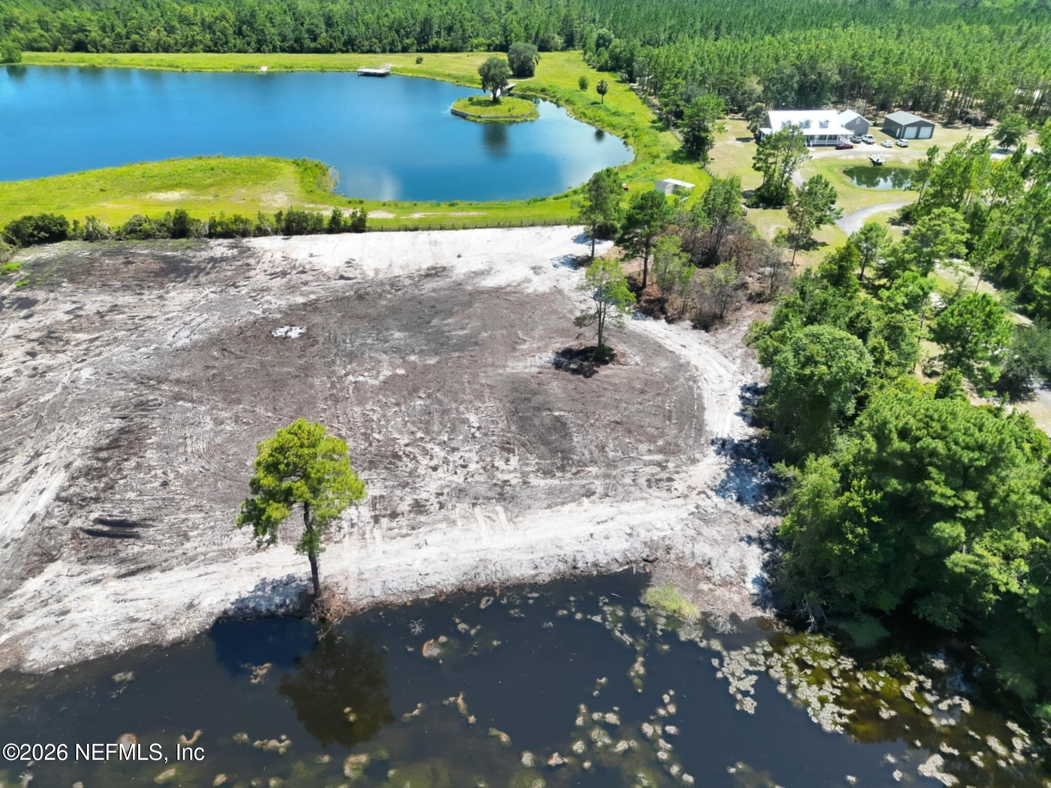 0 Quail Road Callahan, FL 32011 - Photo 5 of 7 a view of a lake with a yard