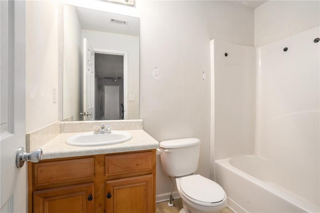 1915 Cornerstone Pass Way Conyers, GA 30012 - Photo 16 of 25 a bathroom with a sink a toilet and shower