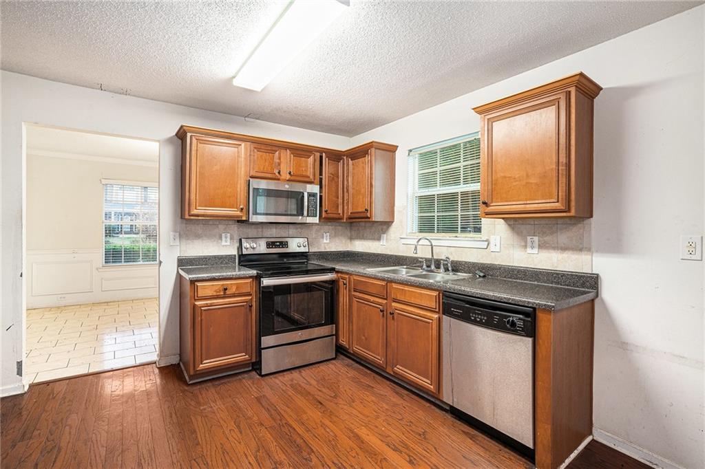 1915 Cornerstone Pass Way Conyers, GA 30012 - Photo 7 of 25 a kitchen with stainless steel appliances granite countertop wooden floor sink stove and granite counter top