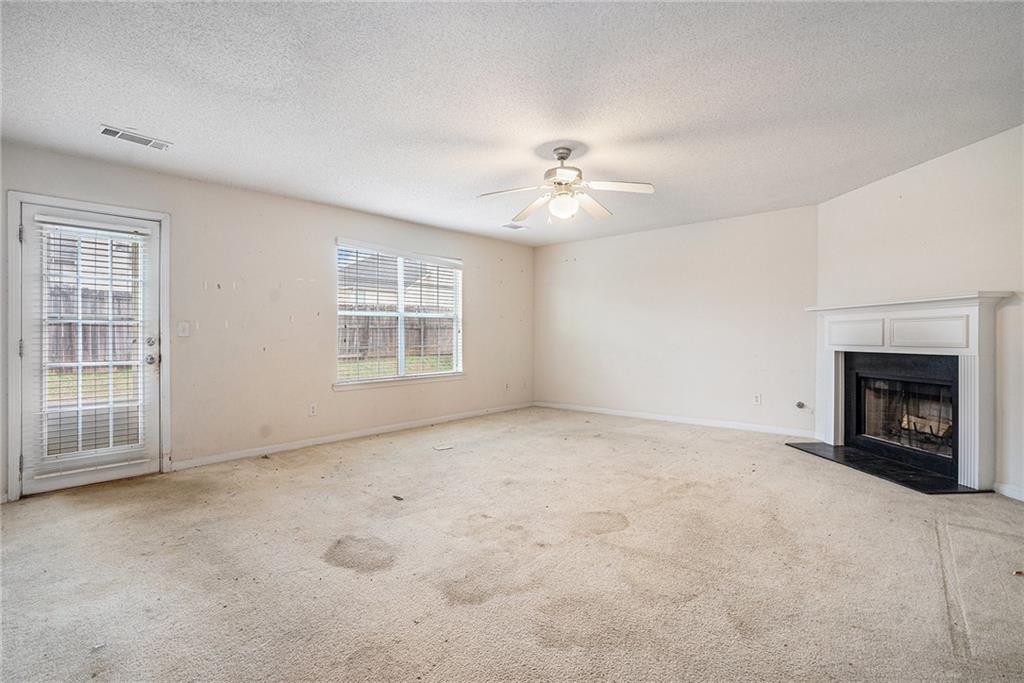 1915 Cornerstone Pass Way Conyers, GA 30012 - Photo 9 of 25 an empty room with windows and fireplace