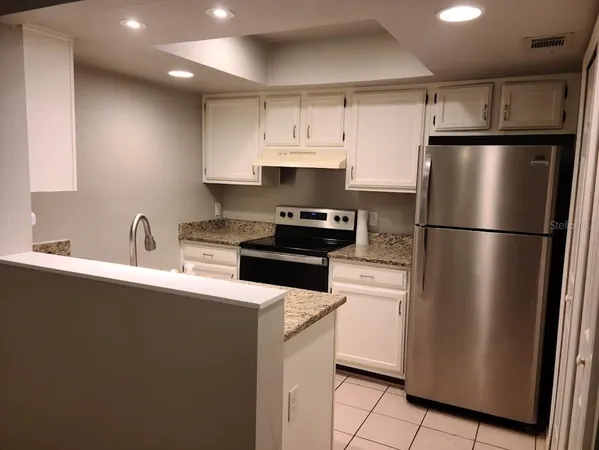 a kitchen with a refrigerator sink and cabinets