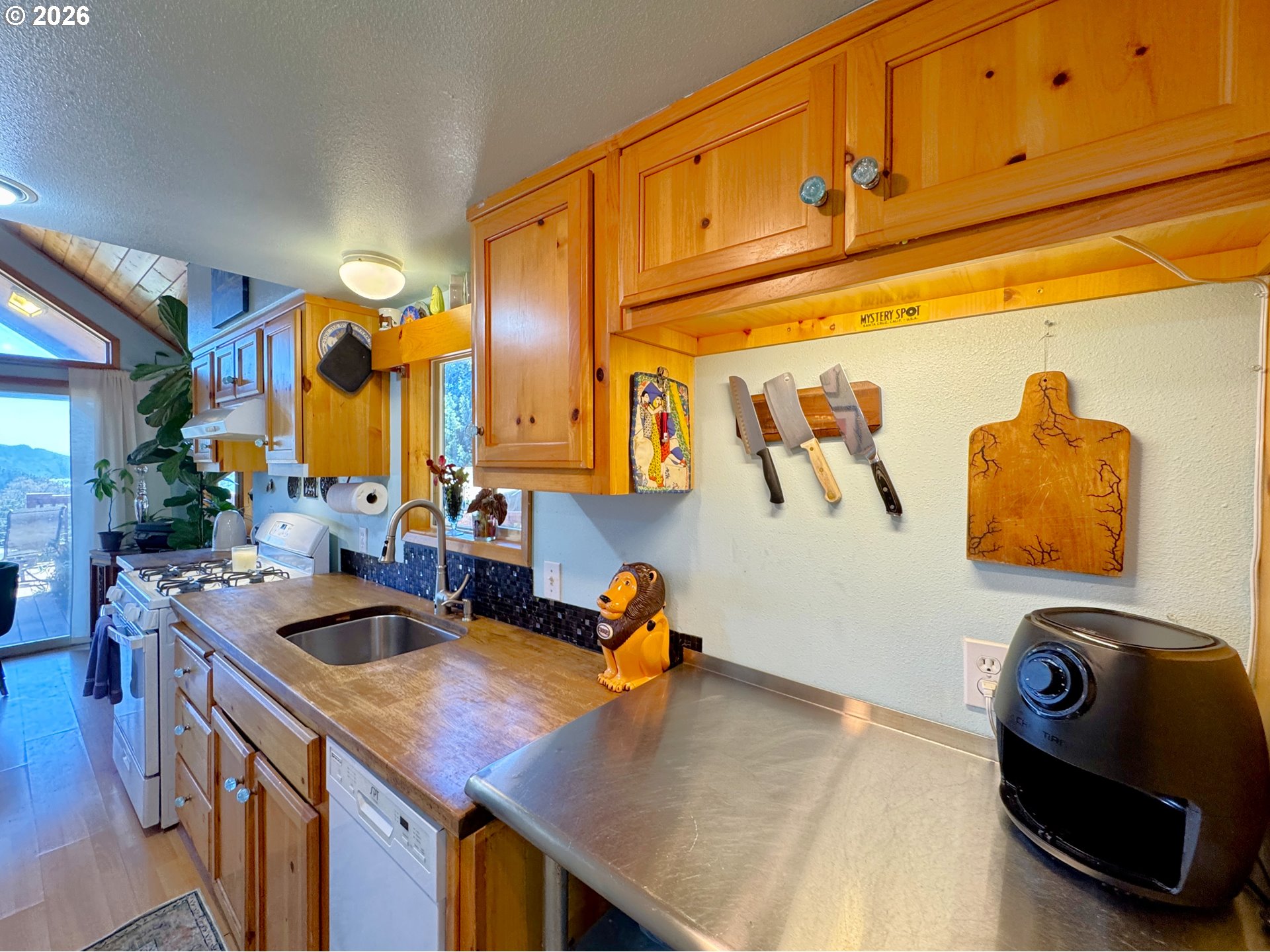 19921 Whaleshead Road, Unit U25 Brookings, OR 97415 - Photo 31 of 47 a kitchen with stainless steel appliances granite countertop a sink a stove and a wooden cabinets