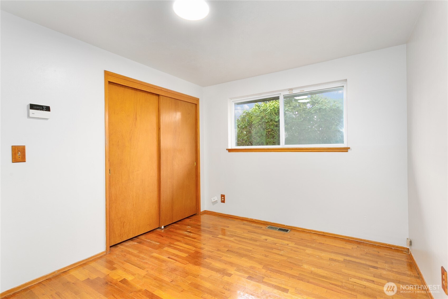 7416 25th Street West Tacoma, WA 98466 - Photo 27 of 39 a view of an empty room with wooden floor and a window