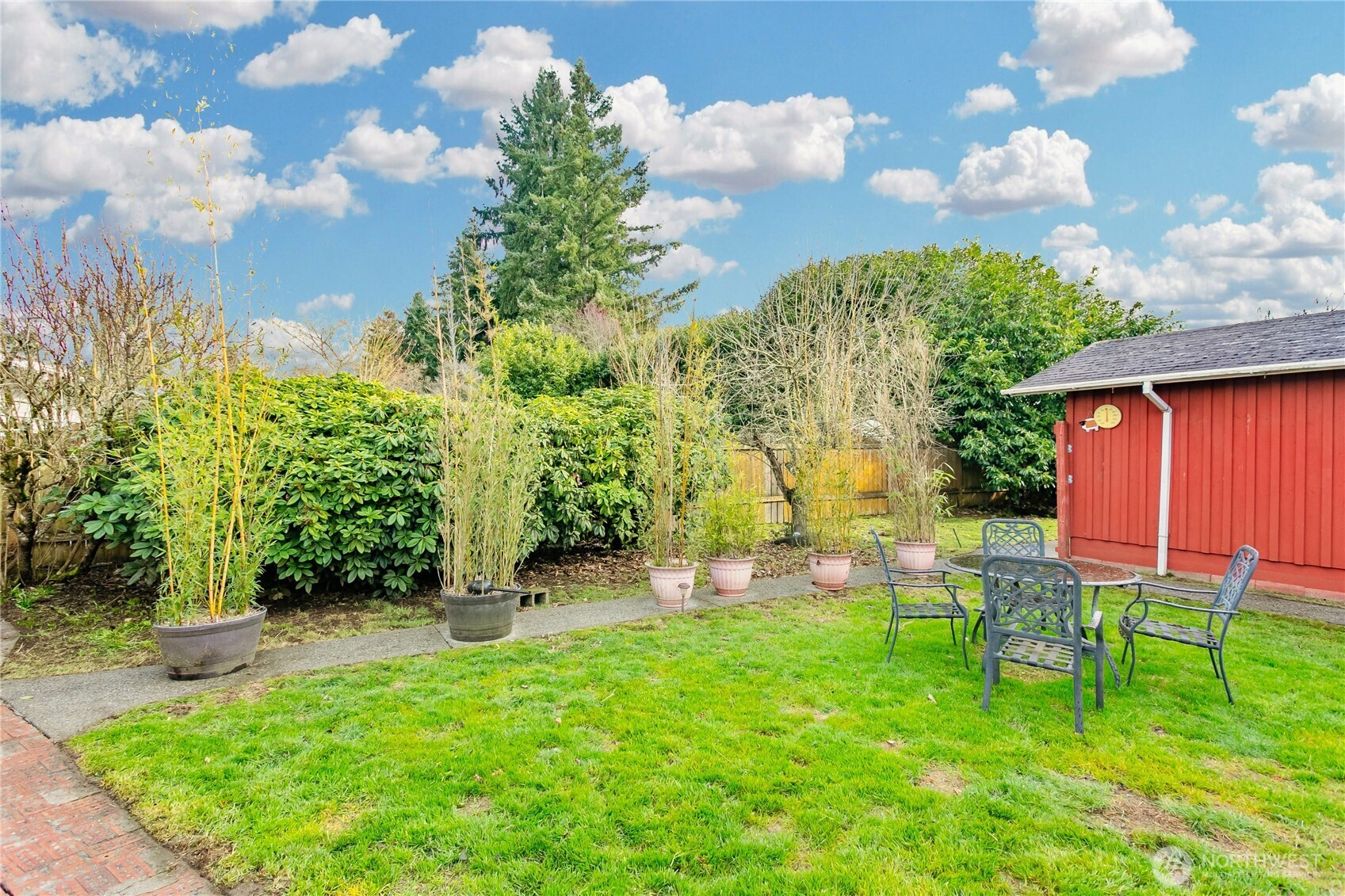 7416 25th Street West Tacoma, WA 98466 - Photo 34 of 39 a backyard of a house with table and chairs plants and large trees
